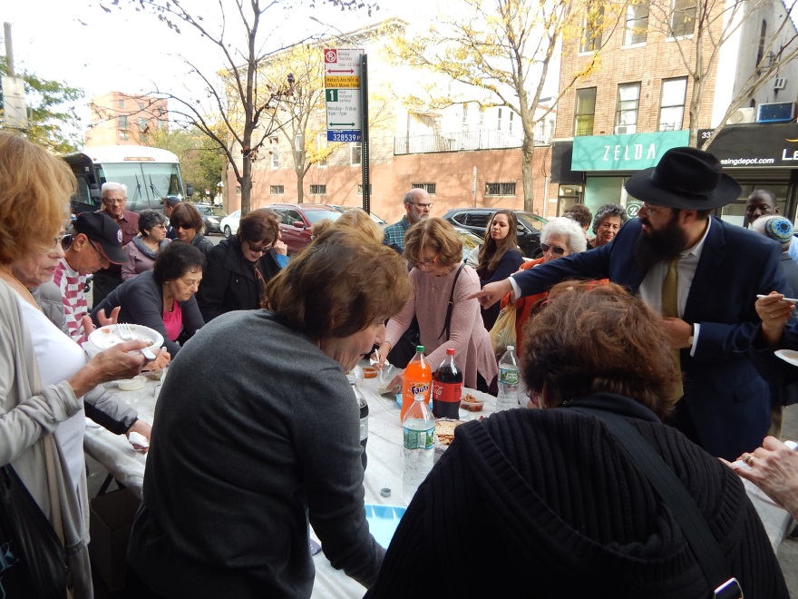 Rabbi Lubin encouraging people to taste the herring.